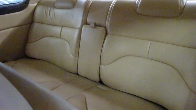 Beige leather car backseat interior.