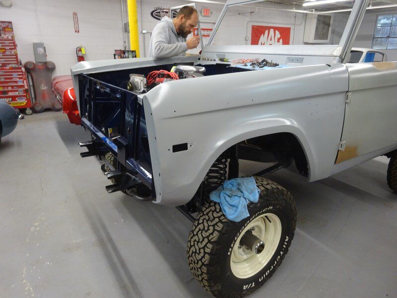 Mechanic restoring a classic Ford Bronco.