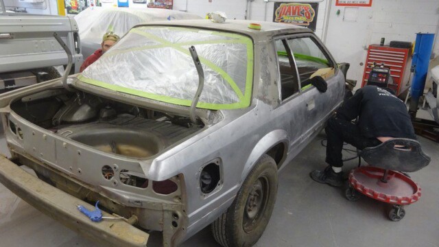 Car body undergoing restoration in auto shop.