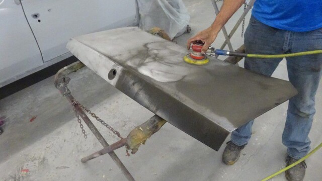 Sanding car part for auto body repair.