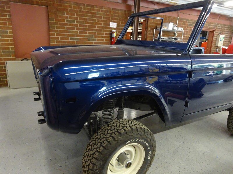 Shiny blue Bronco front quarter in garage
