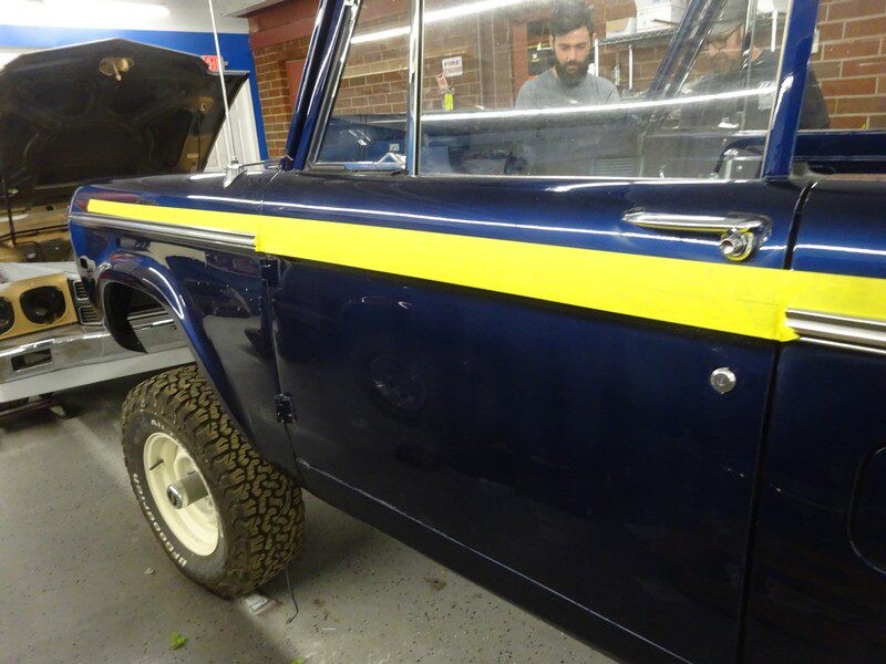 Blue Ford Bronco with yellow stripe.