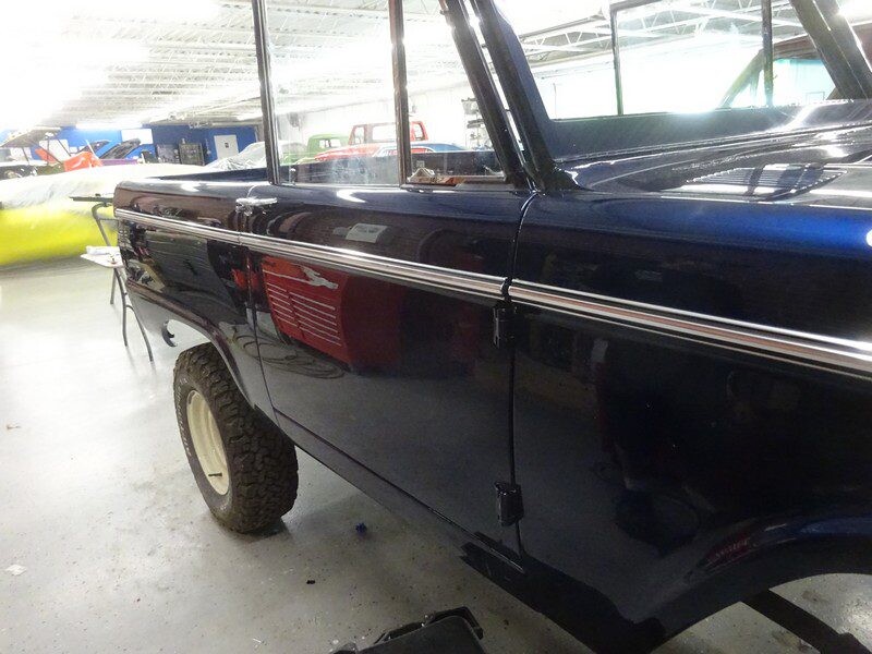 Dark blue Ford Bronco side profile.