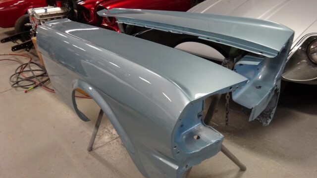 Painted light blue Mustang body panels.