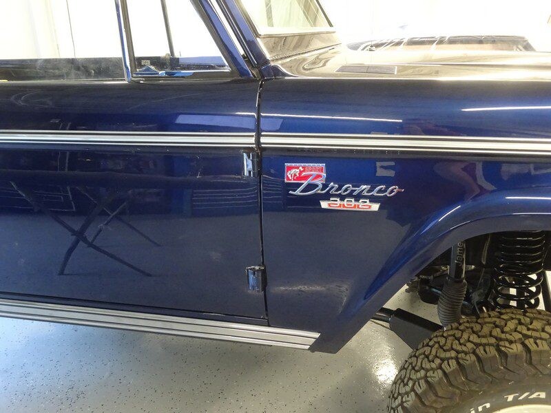 Here's an alt tag for the image: Blue Ford Bronco 302 side view.