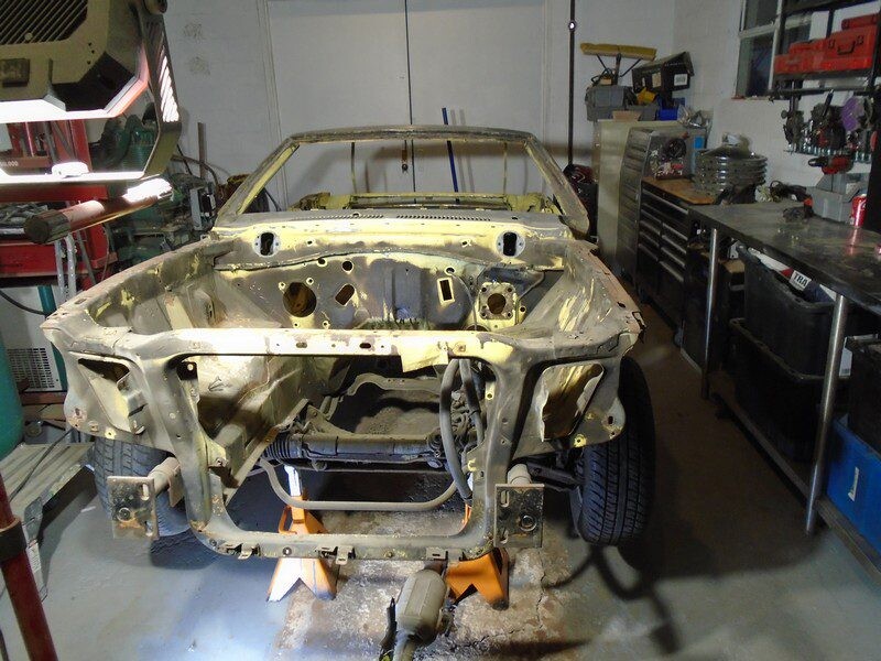 Yellow classic car restoration in progress.