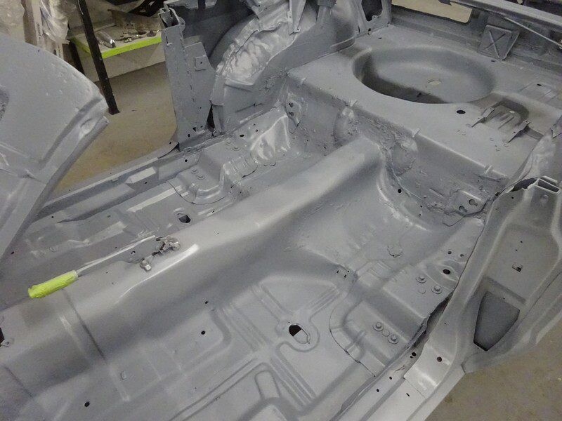 Primered car chassis interior restoration.