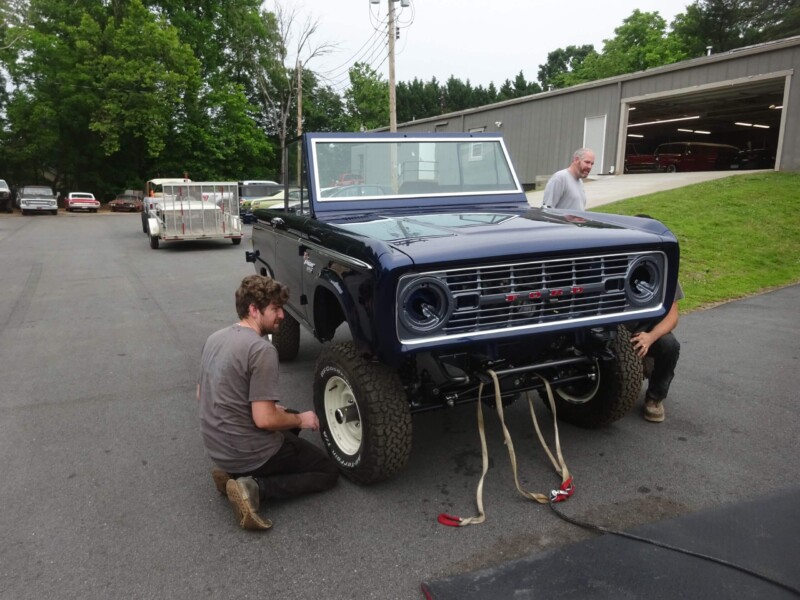 Mechanics working on a classic Ford Bronco.