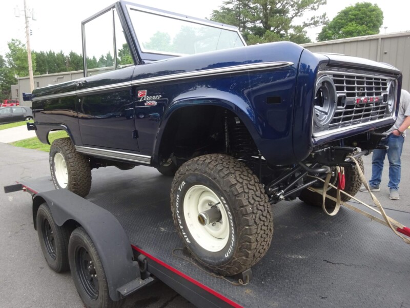 Restored blue Ford Bronco on trailer.