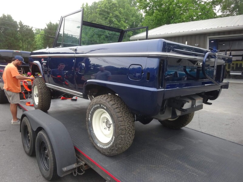 Here's an alt tag for the image: Blue Ford Bronco on a trailer.