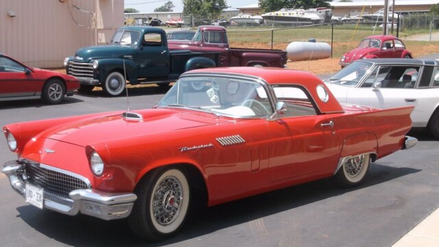 Red classic Thunderbird car parked outdoors.