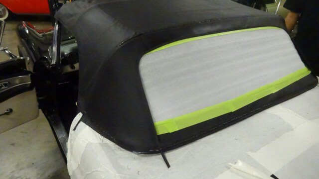 Black convertible top being installed.