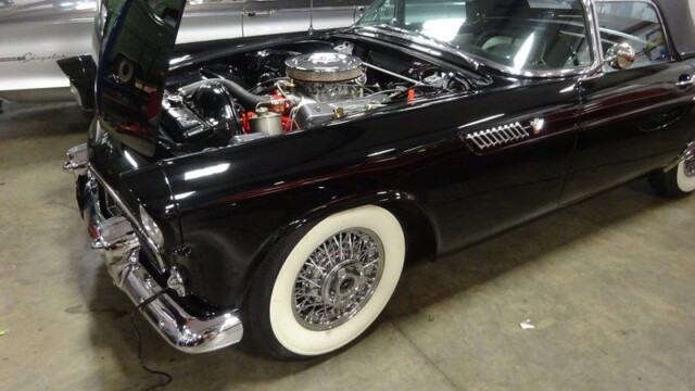 Black classic Thunderbird with hood up.