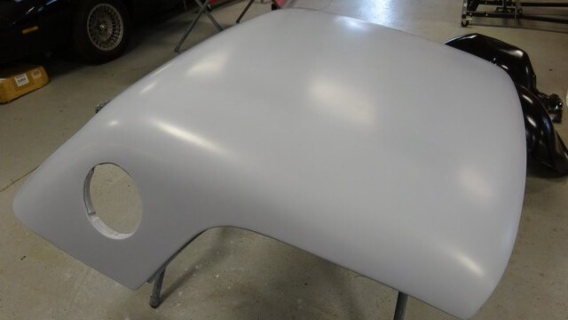 Unpainted car body part in shop.