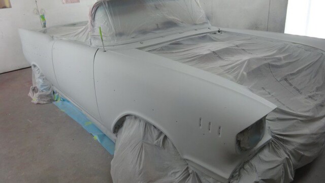 Primered classic car under plastic wrap.