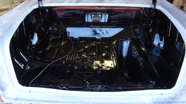Black painted car trunk during restoration.