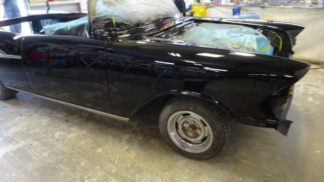 Black classic car in auto shop.