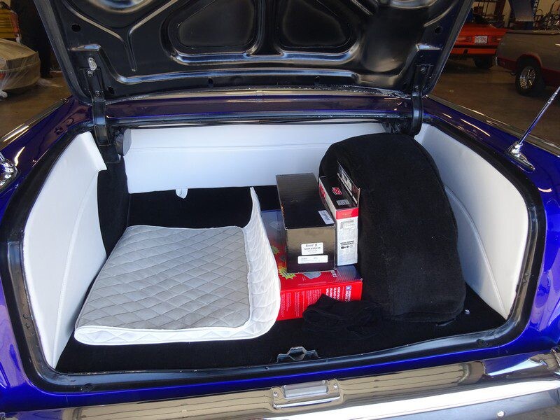 Custom car's trunk with spare tire and boxes.