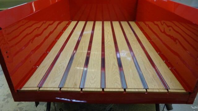 Red truck bed with wood planks.