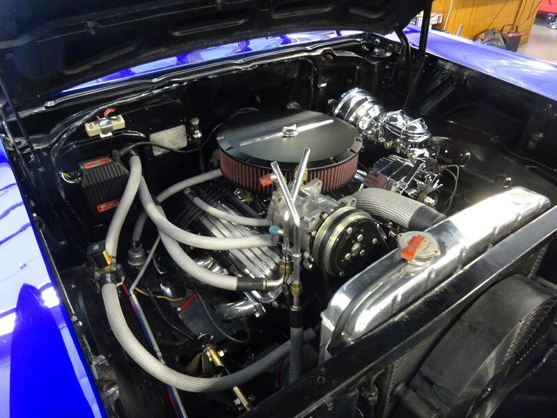 Custom engine in a blue classic car.