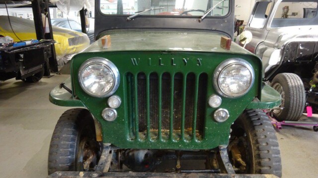 Green Willy's Jeep in a garage.