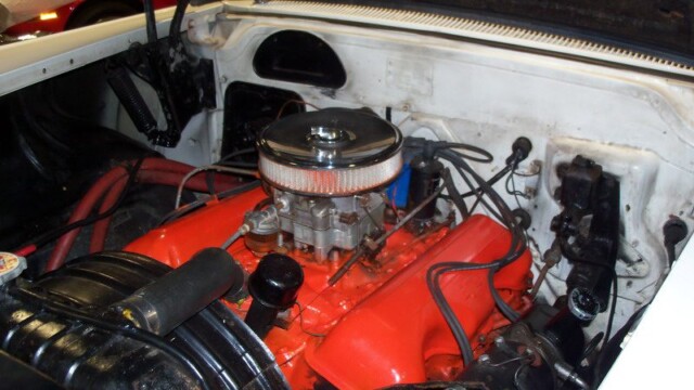 Classic car's red engine under the hood.