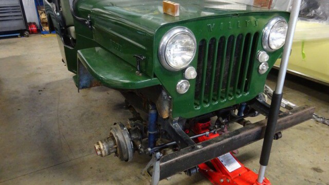 Green Willys Jeep undergoing restoration.