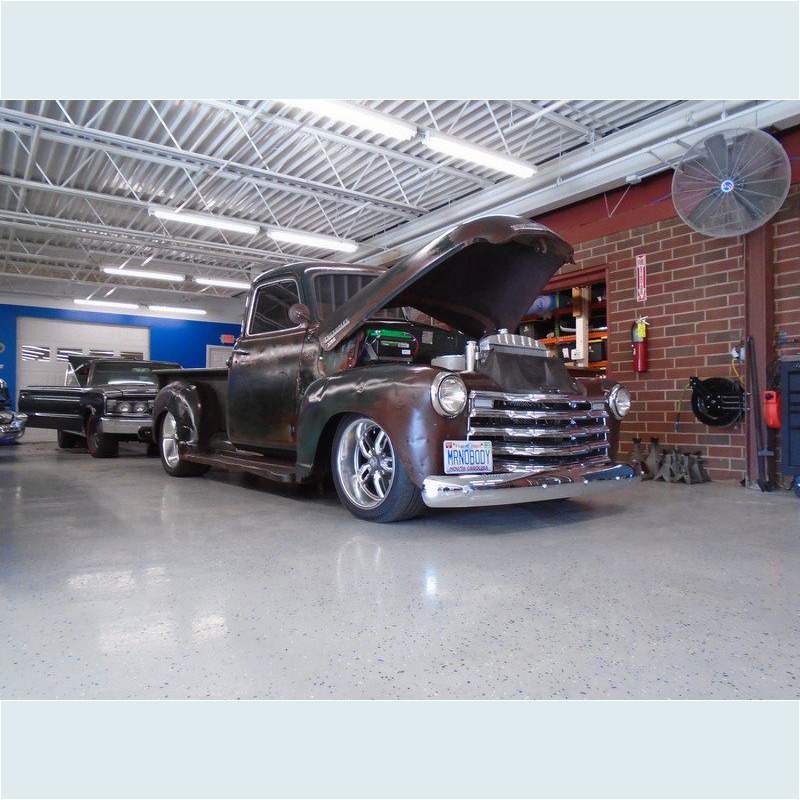 Here's an alt tag for the image: Vintage truck in a garage.