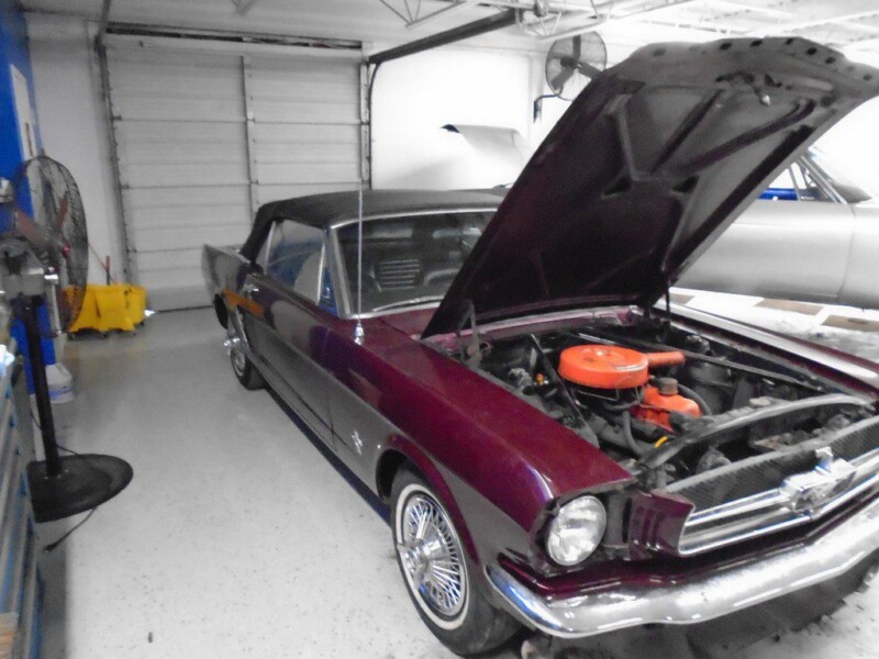 Burgundy Ford Mustang convertible, hood up.