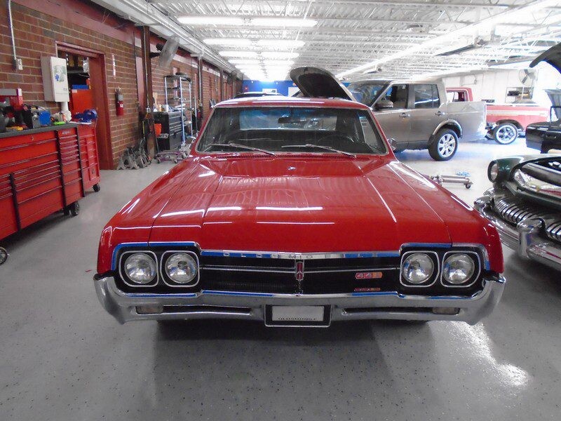 Red Oldsmobile Cutlass in auto shop.