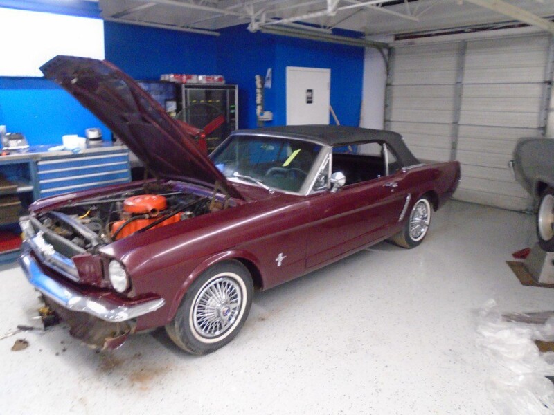 Maroon Ford Mustang convertible under repair.