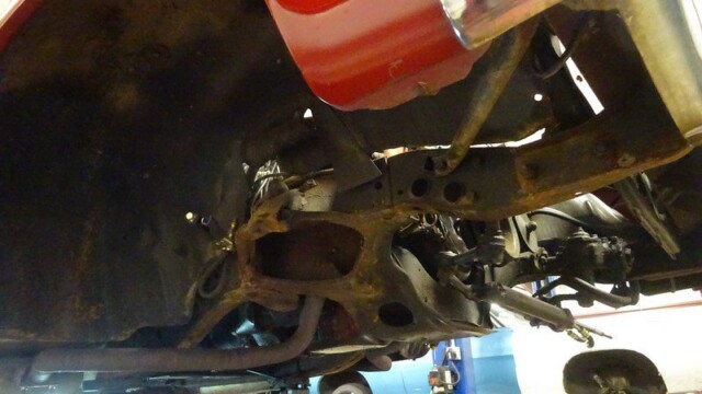 Rusty car undercarriage needing repair.