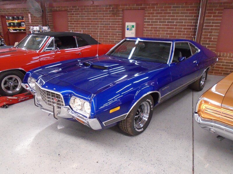 Blue Ford Torino muscle car in garage.