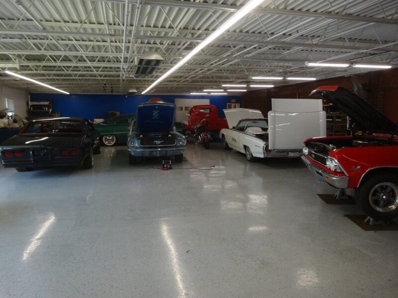 Classic cars in a well-lit garage.