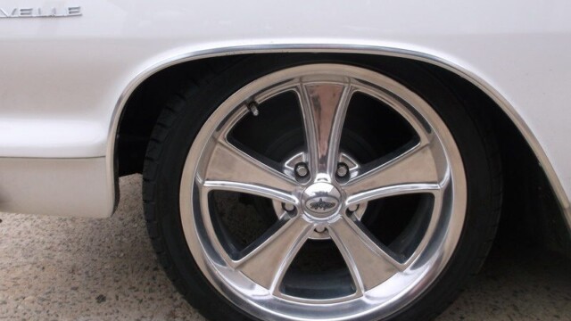 White car's chrome wheel close-up.