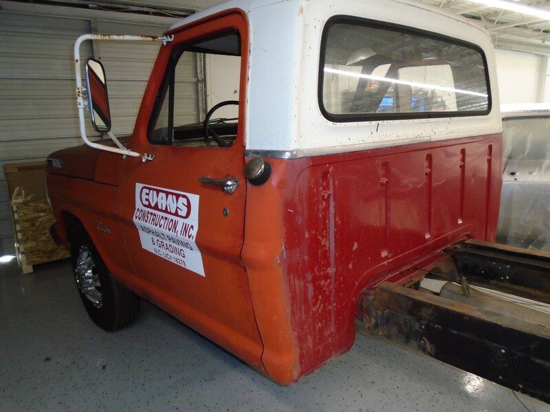 Rusty red Ford pickup truck cab.