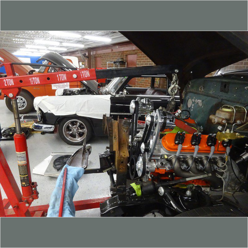 Car engine being installed in a garage.