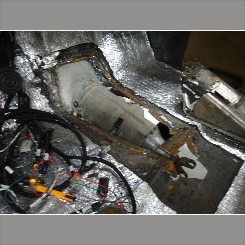 Car transmission installation in progress.
