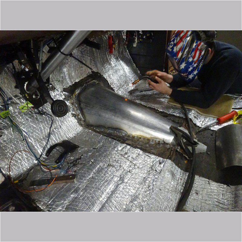 Welder repairing metal car part.