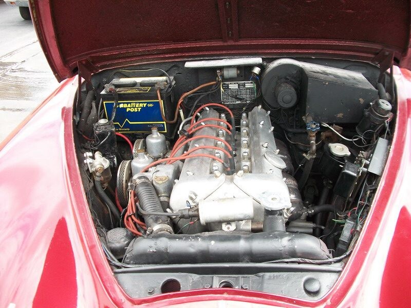Classic car engine with open hood.