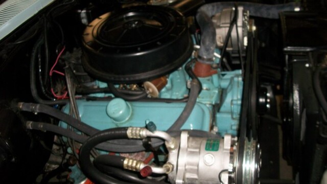 Classic car engine with AC compressor.