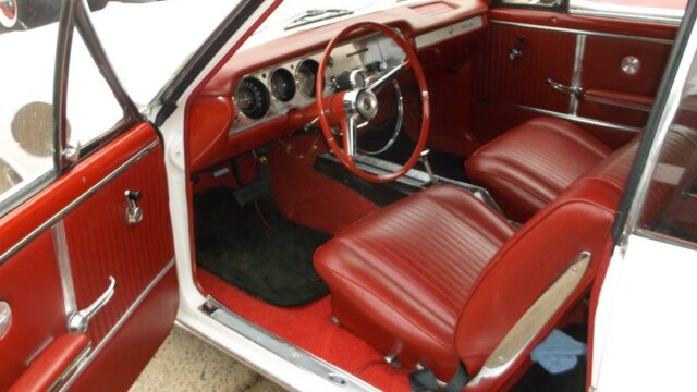 Red interior of a classic white convertible.