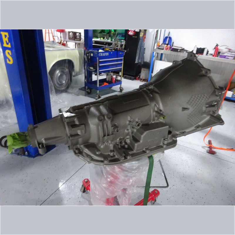 Painted car transmission on shop floor.
