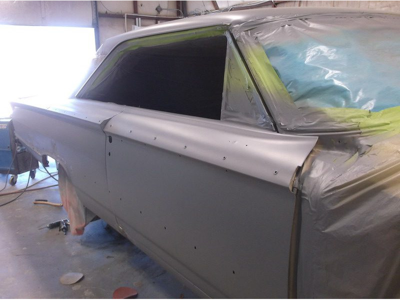 Primered classic car body panel in progress.