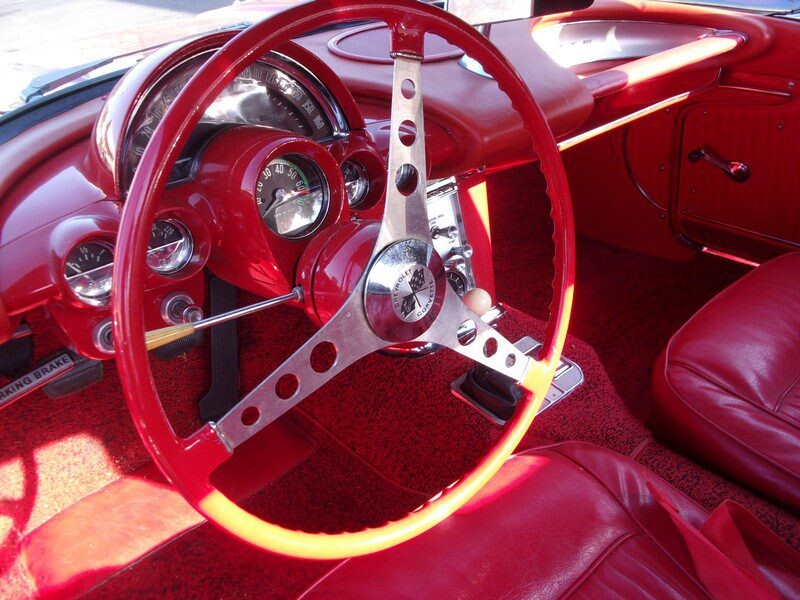 Red Corvette interior and steering wheel.