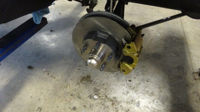 Car brake assembly with gold caliper.