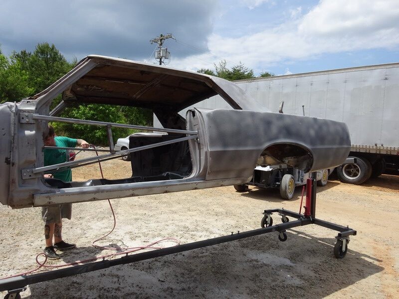 Person sanding a classic car body.