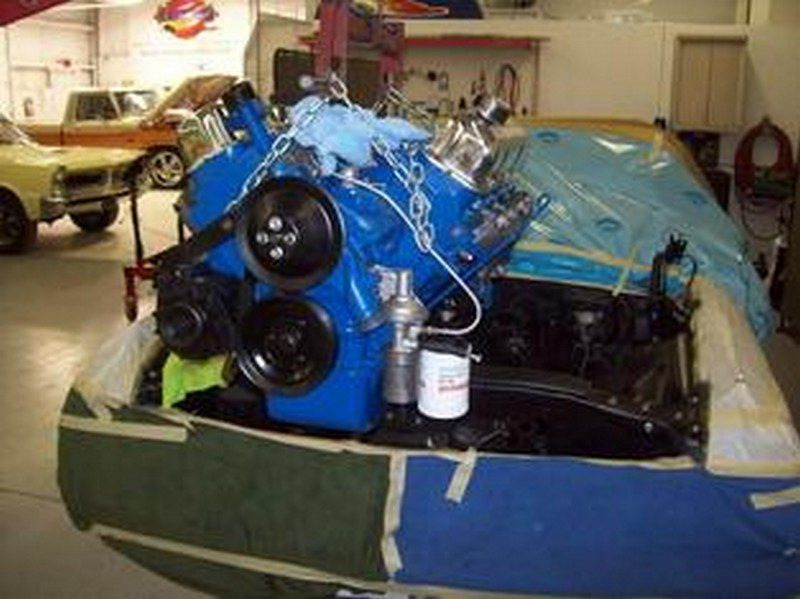Blue Ford engine installed in car.