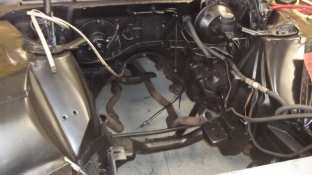 Empty black engine bay with headers visible