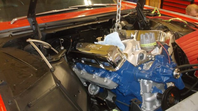 Blue Ford engine installed in red car.